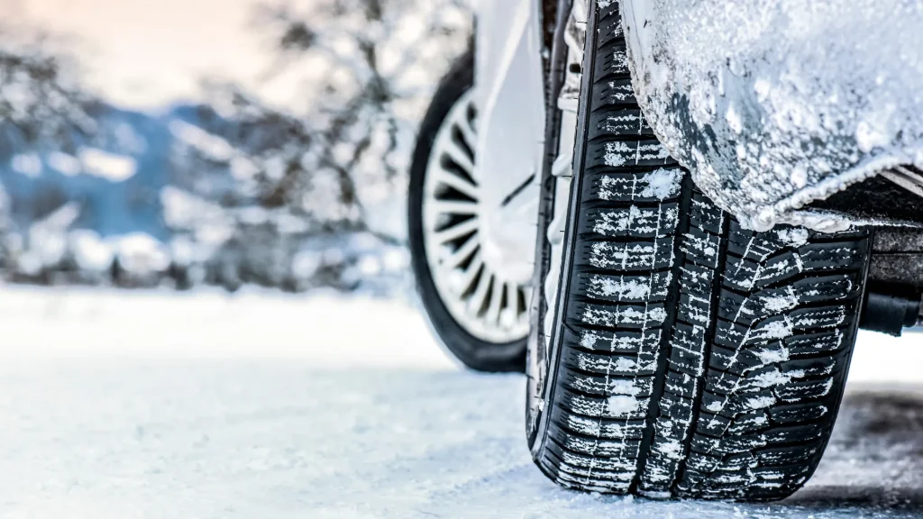 car tires in winter with scenic snowy background