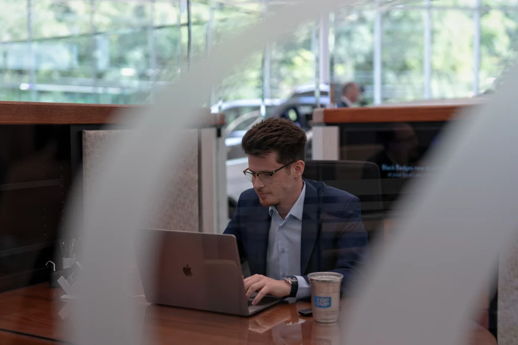 Rohrich Lexus car salesman sitting at his desk with dual screens